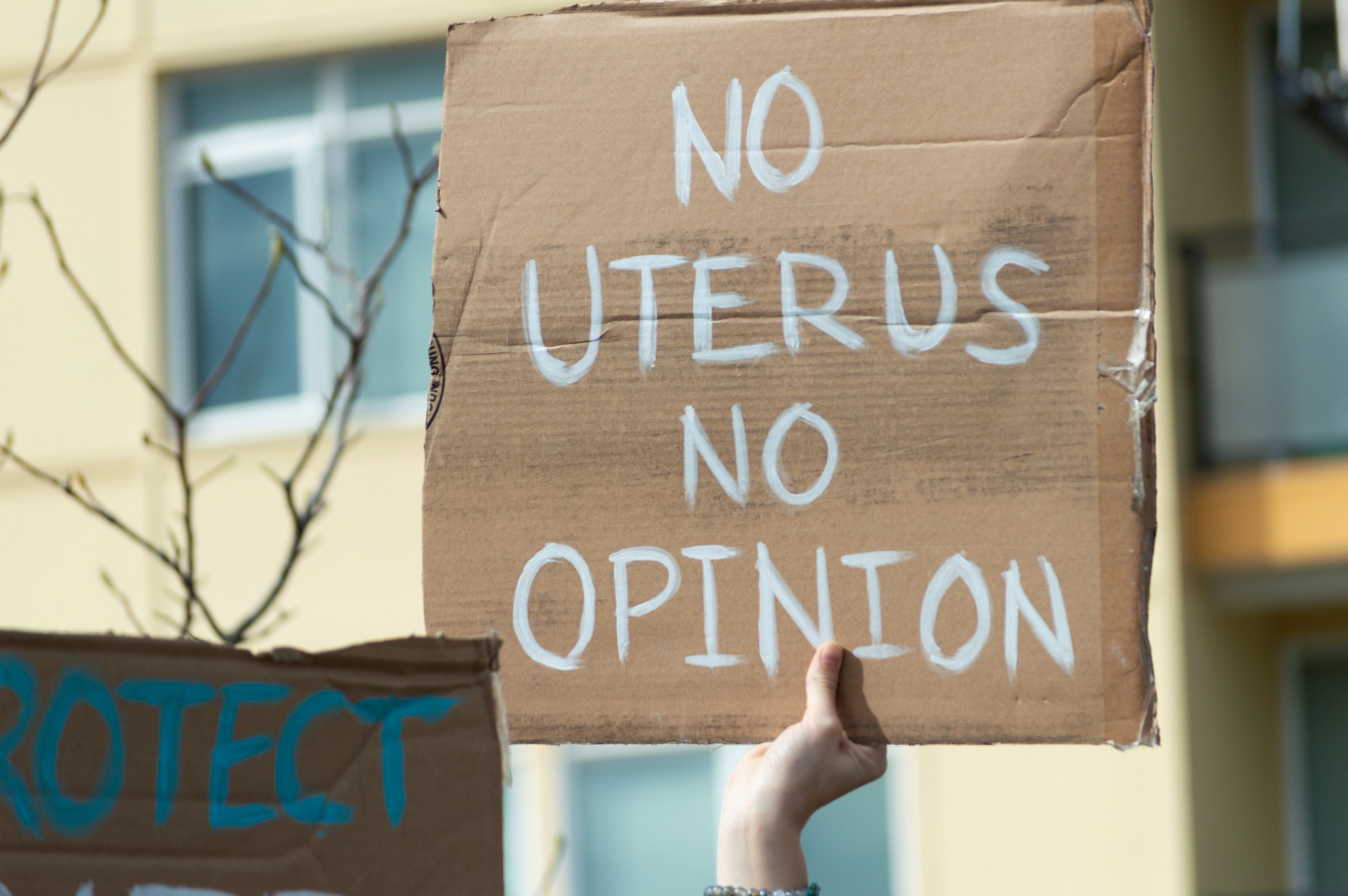 A hand holding a sign supporting pro-choice during a planned parenthood rally for abortion justice.